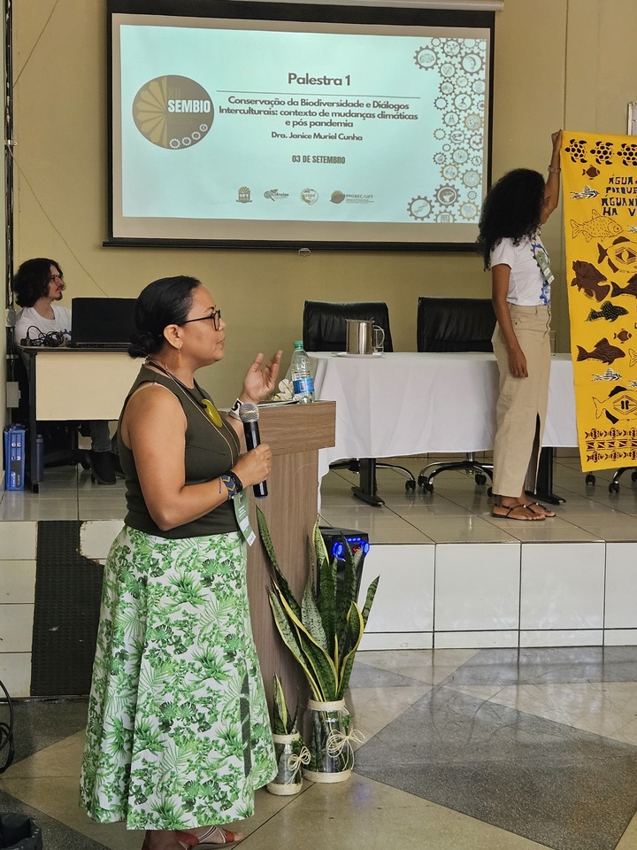 professora palestrando com o microfone na mão